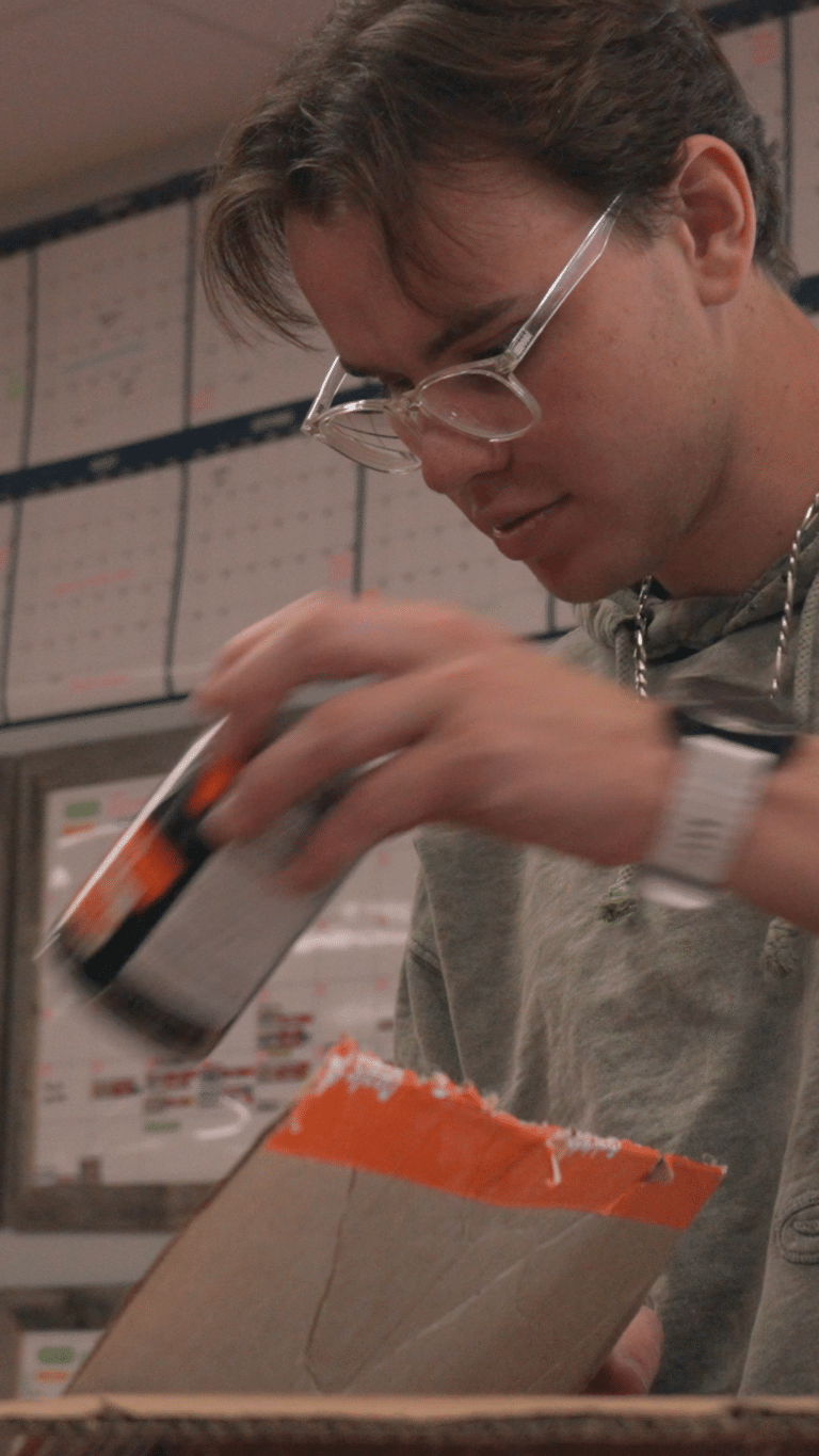 white young adult male with glasses putting canned food in a blox